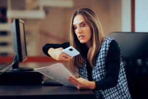 woman taking a photo of a document at workplace